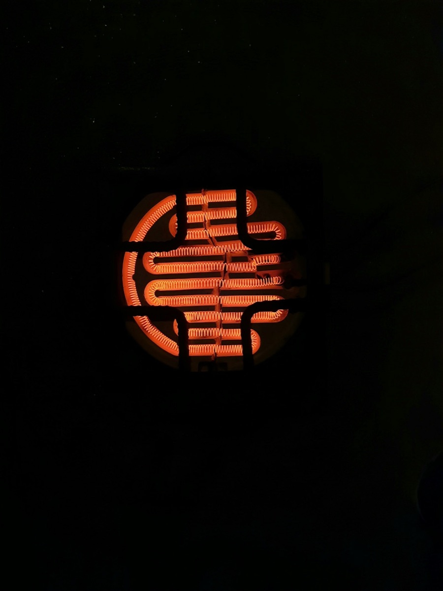 Close-up of a multi-pocket electron beam evaporation source glowing softly during operation.