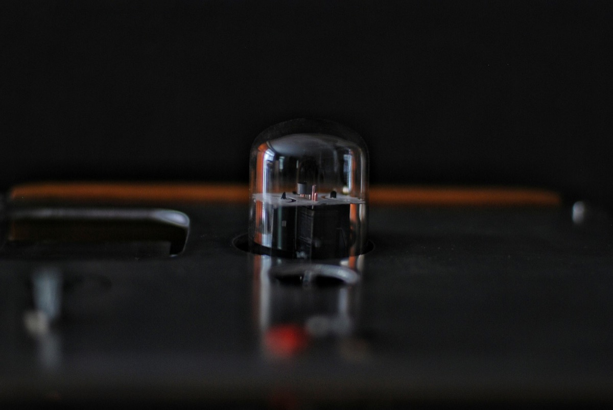 Close-up of a sleek electron beam evaporation source glowing softly inside a vacuum chamber.